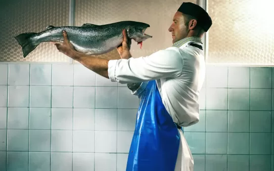 Salmón de criadero y un trabajador